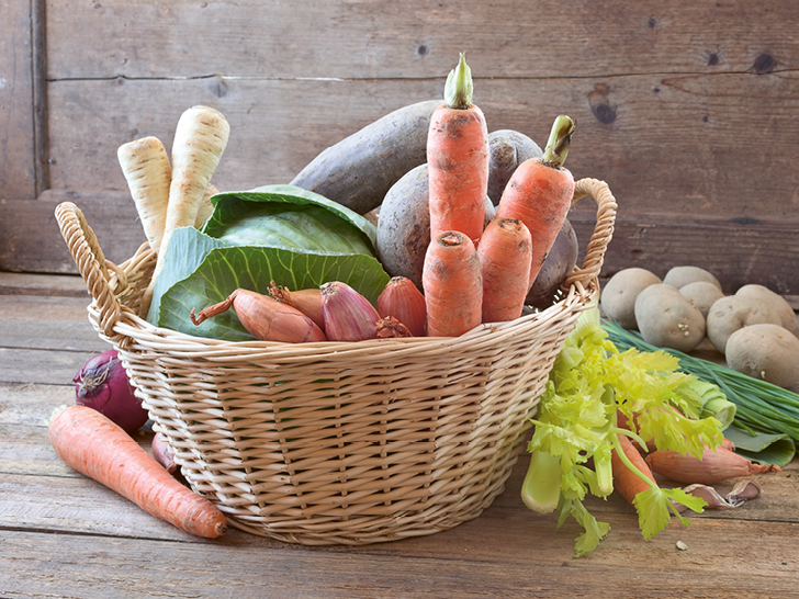 Ein Korb voller Gemüse wie Karotten, Rande, Rüben, Kartoffeln und Schnittlauch.